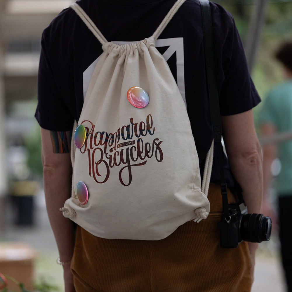 Woman with camera wearing a gym-sack with reflective buttons