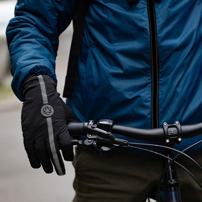 man, holding a bicycle , wearing winter clothe and gloves