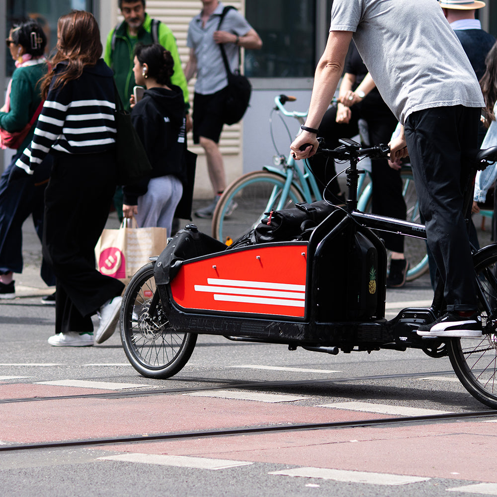 Man riding a cargo bicycle in traffic