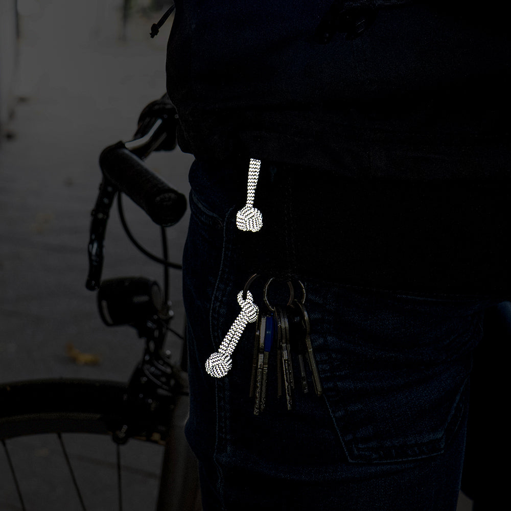 reflective loops attached to a key ring on jeans at night with reflection
