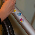 hand applying reflective sticker set on bicycle frame