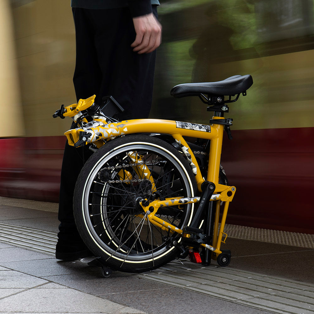 folded bicycle with man, waiting at train station
