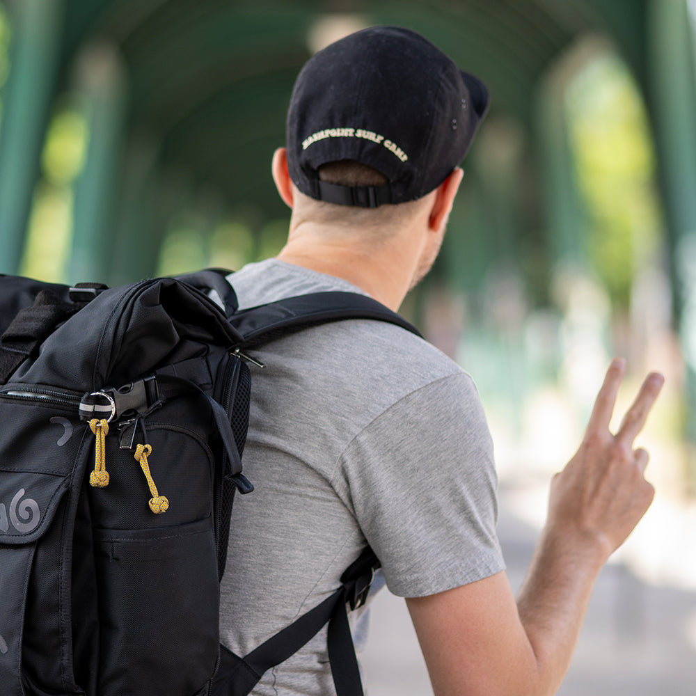 man doing the peace sign and wearing a backpack