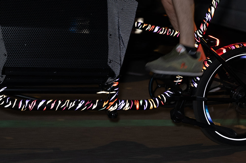 Reflective design applied on cargo bicycle frame at night with rider