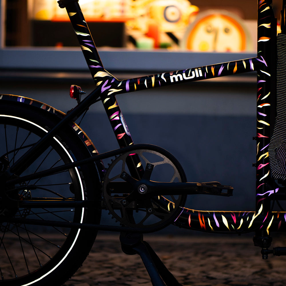 cargo bicycle parked in front of shop at night with reflective stickers