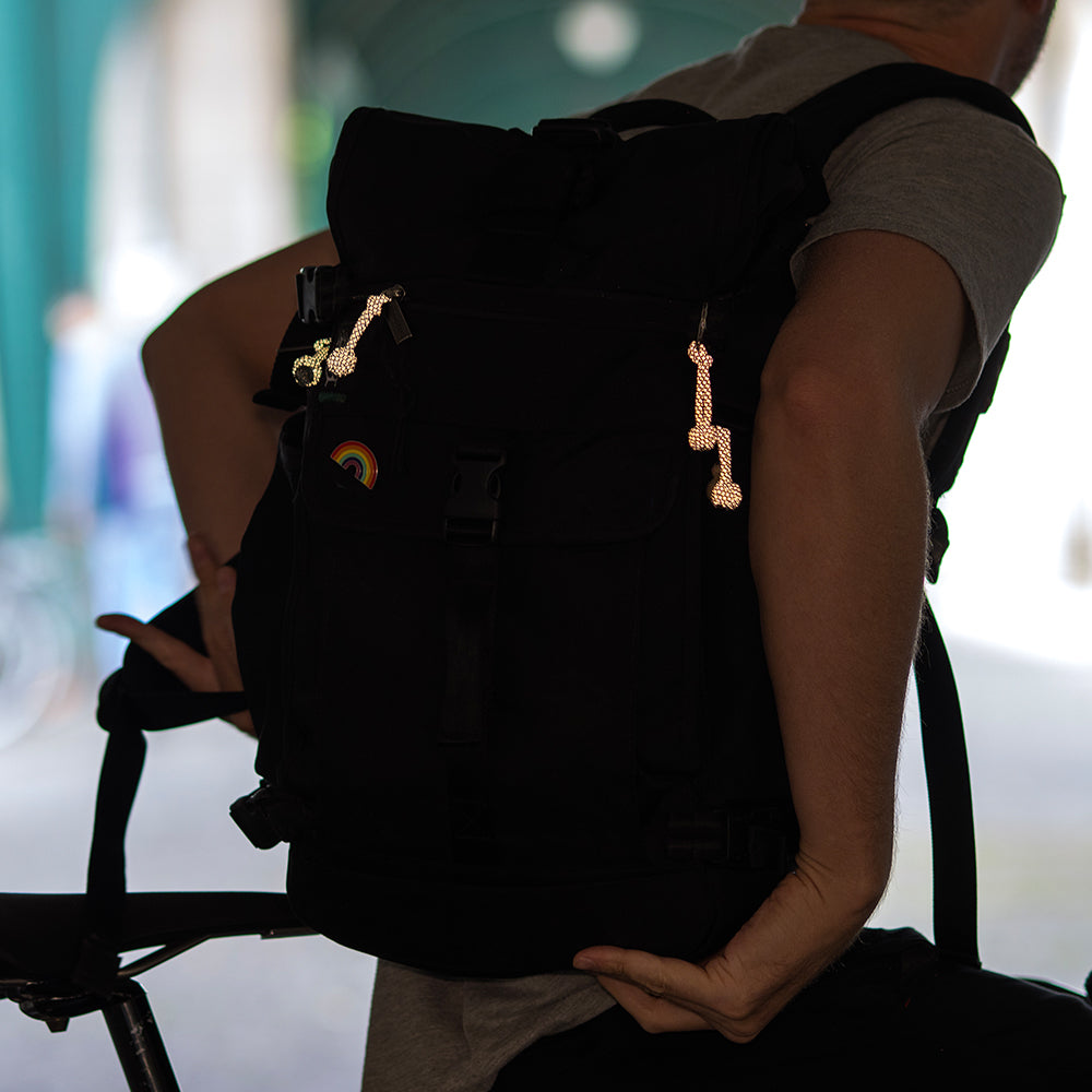 man wearing backpack with reflective loops attach to it