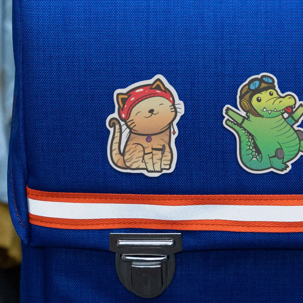 Reflektierende Aufkleber Stoff Textil Katze „Miez“ und Krokodil „Freddy“ aus der Produktserie „Reflective Friends“ die auf einen blauen Schulrucksack geklebt in Detailansicht. Von REFLECTIVE Berlin.