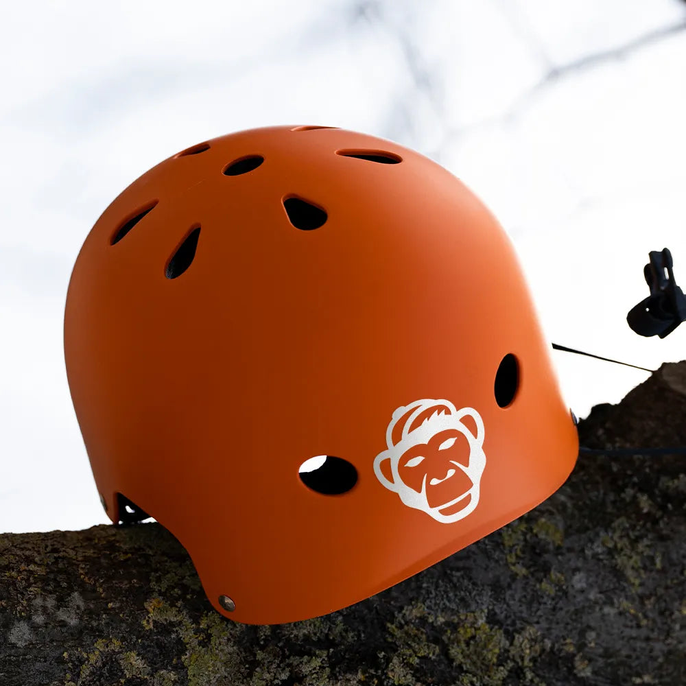 Reflektierender Aufkleber „Affe“ in Farbvariante „weiß“ auf einem orangen Fahrradhelm vor weißem Hintergrund von REFLECTIVE Berlin.