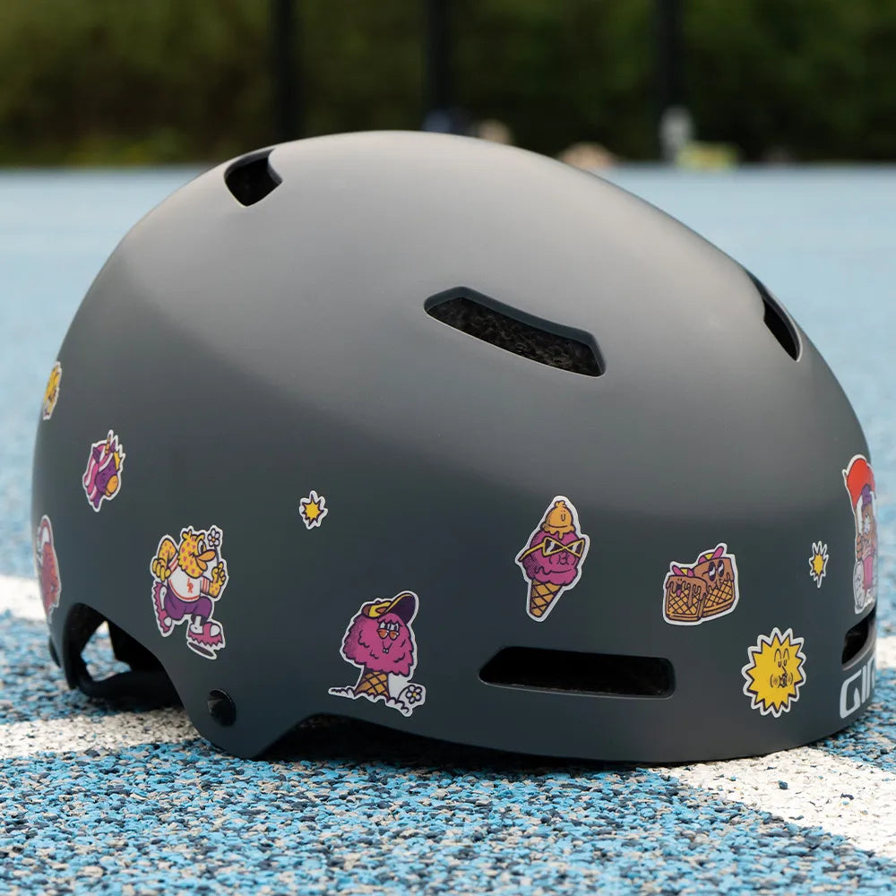 Reflektierende Aufkleber Künstleredition „C. Miller“ auf grauem Fahrradhelm auf einem Basketballplatz liegt. Von REFLECTIVE Berlin