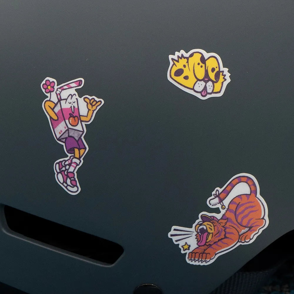 Reflektierende Aufkleber Künstleredition „C. Miller“ auf schwarzem Fahrradhelm. Detailaufnahme von drei Aufklebern aus dem Set: Trinktüte, Tiger und Katze. Von REFLECTIVE Berlin
