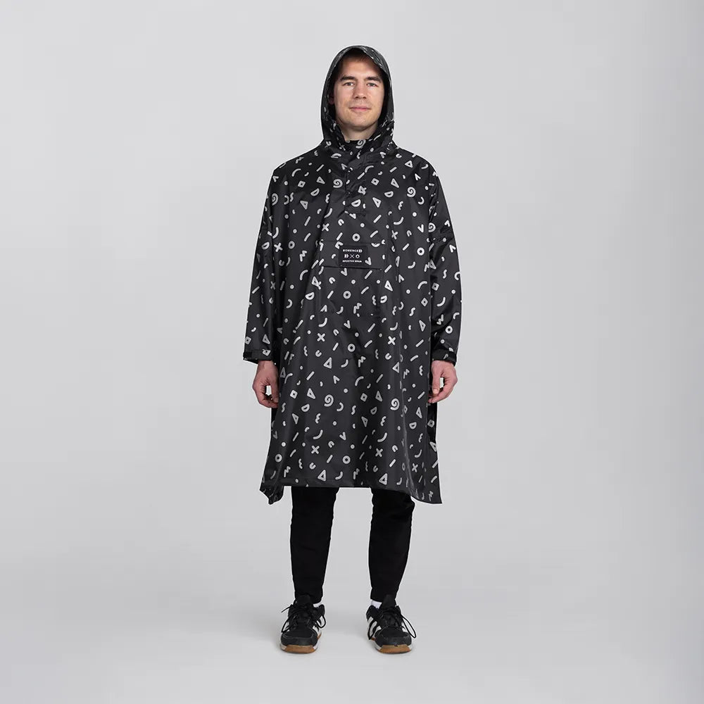 reflektierender Fahrrad Regenponcho in Farbvariante „Doodle“ getragen von einer Person, die frontal in die Kamera schaut vor weißem Hintergrund. Kollaboration von Bomance und REFLECTIVE Berlin.