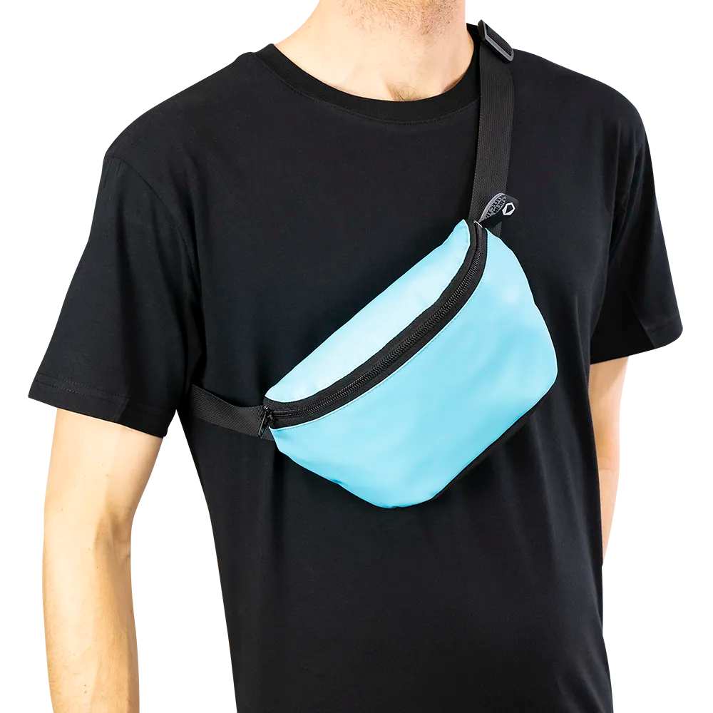 reflektierende Gürteltasche/fanny pack/Pouch in Farbvariante „Blue Curacao“ wird von einer Person am Oberkörper getragen. Arrangement von REFLECTIVE Berlin.