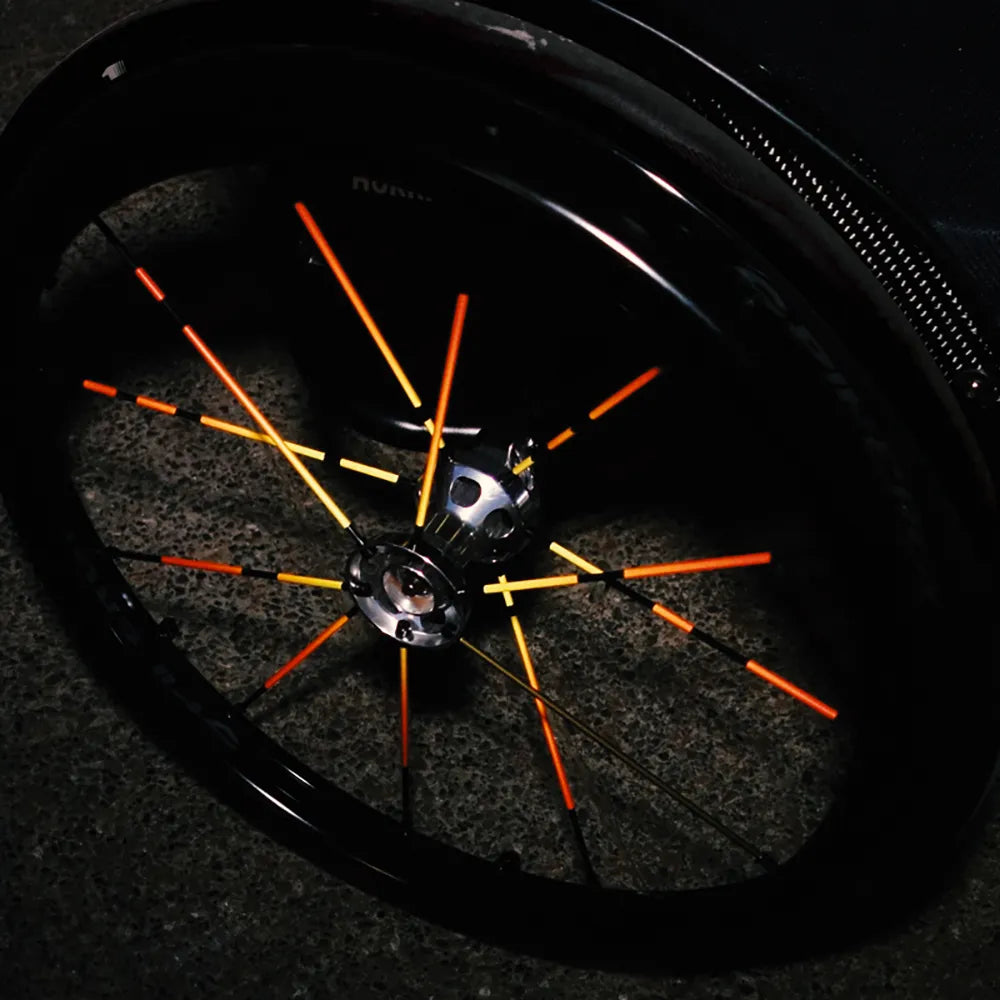 Reflektierender Speichen Aufkleber „Spokes“ in Farbvariante „Feuer“ auf den Speichen von einem Rollstuhl. Blitzlicht hebt die Reflexion der Speichen Aufkleber hervor. Von REFLECTIVE Berlin.
