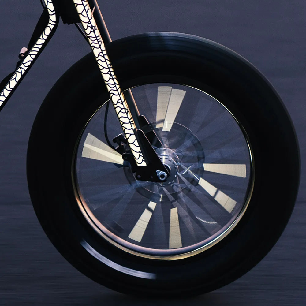 Reflektierender Speichen Aufkleber „Spokes“ in Farbvariante „weiß“ auf den Speichen eines rotierenden Laufrads zur Hervorhebung der Reflexion. Rahmen und Gabel des Fahrradrahmens sind mit reflektierenden XL Sticker „Flow“ in Farbvariante „weiß“ beklebt. Von REFLECTIVE Berlin.