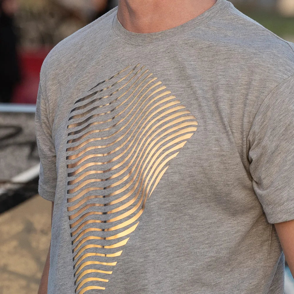 Detail Oberkörper. Person trägt das reflektierende T-Shirt Dune in Grau von REFLECTIVE Berlin, das T-Shirt reflektiert Sonnenlicht.