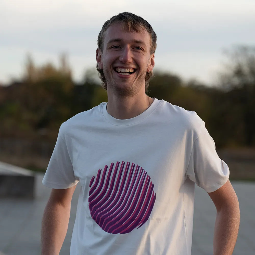 Nahaufnahme vom Reflektierenden T-Shirt Sunset in der Farbvariante Off-white. Das T-Shirt wird von einer lachenden Person bei Tageslicht getragen. Der runde reflektierende Print auf dem T-Shirt von REFLECTIVE Berlin wird bei Tageslicht ohne Reflexion dargestellt.