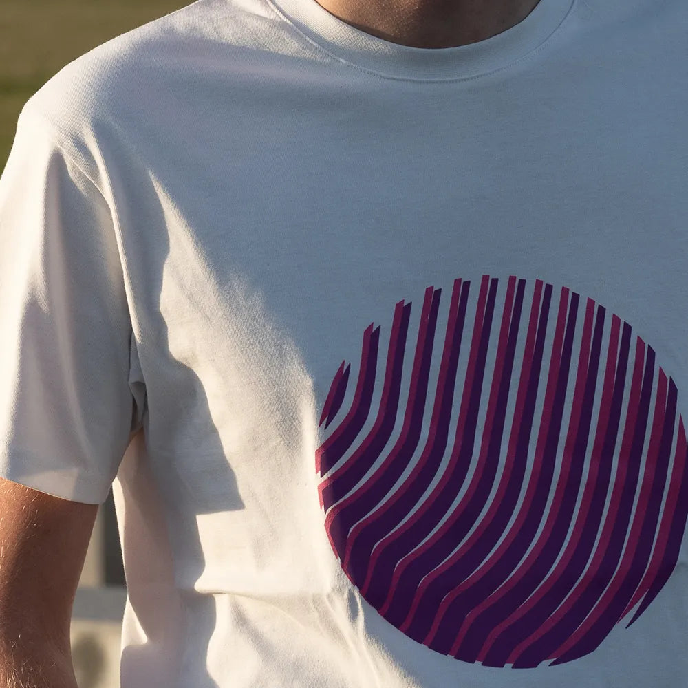 Nahaufnahme vom Reflektierenden T-Shirt Sunset in der Farbvariante Off-white von REFLECTIVE Berlin. Das T-Shirt wird von einer Person bei Tageslicht getragen. Der runde reflektierende Print ist im Fokus der Aufnahme und wird bei Tageslicht ohne Reflexion dargestellt.