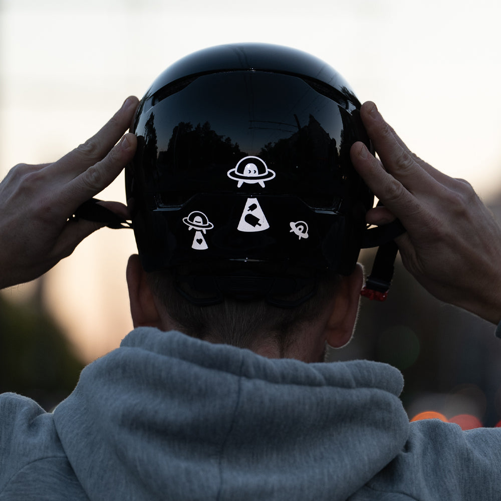 Man puting on his helmet, with reflective UFO stickers