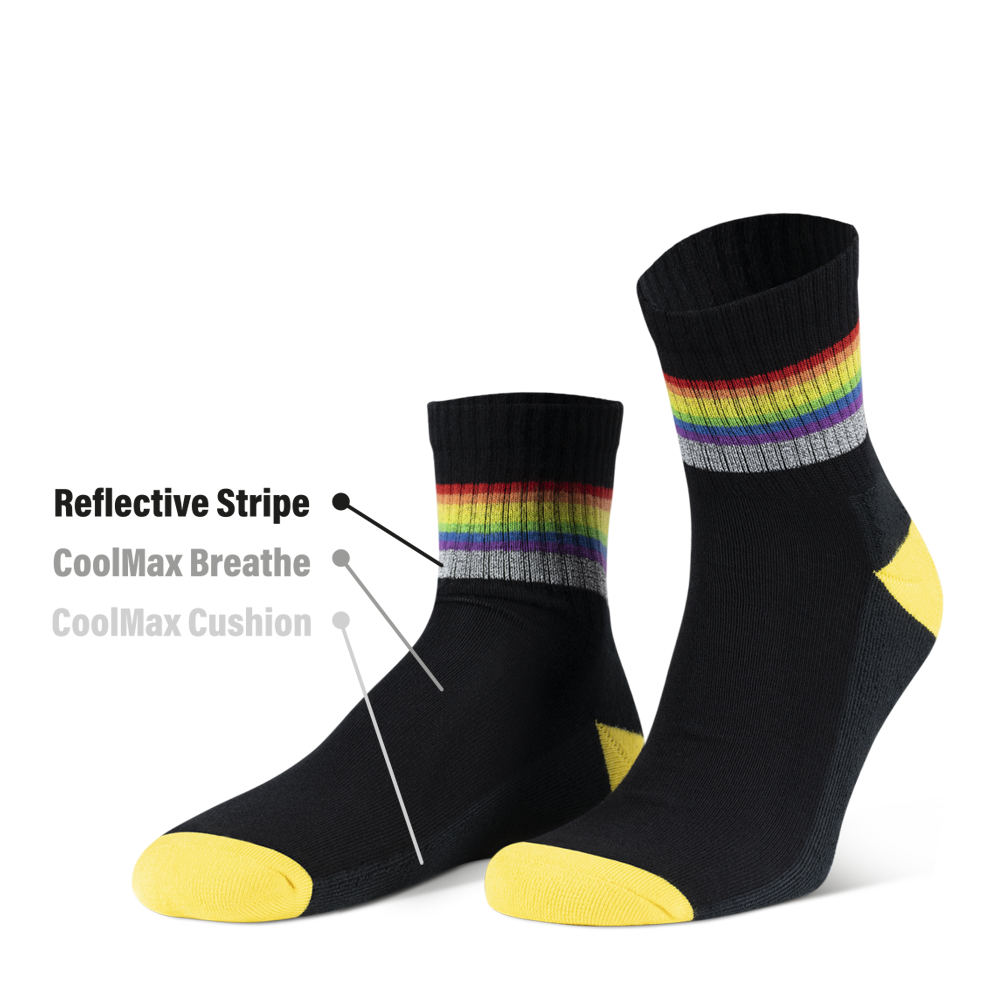 reflektierende schwarze Socken in Farbvariante „schwarz Regenbogen“ mit Streifen in Regenbogen Optik und hoch reflektierendem Streifen von REFLECTIVE Berlin. Markierungen mit Text von oben nach unten: Reflektierender Streifen, CoolMax Breathe auf der Oberseite der Socken, „CoolMax Cushion“ auf der Unterseite.