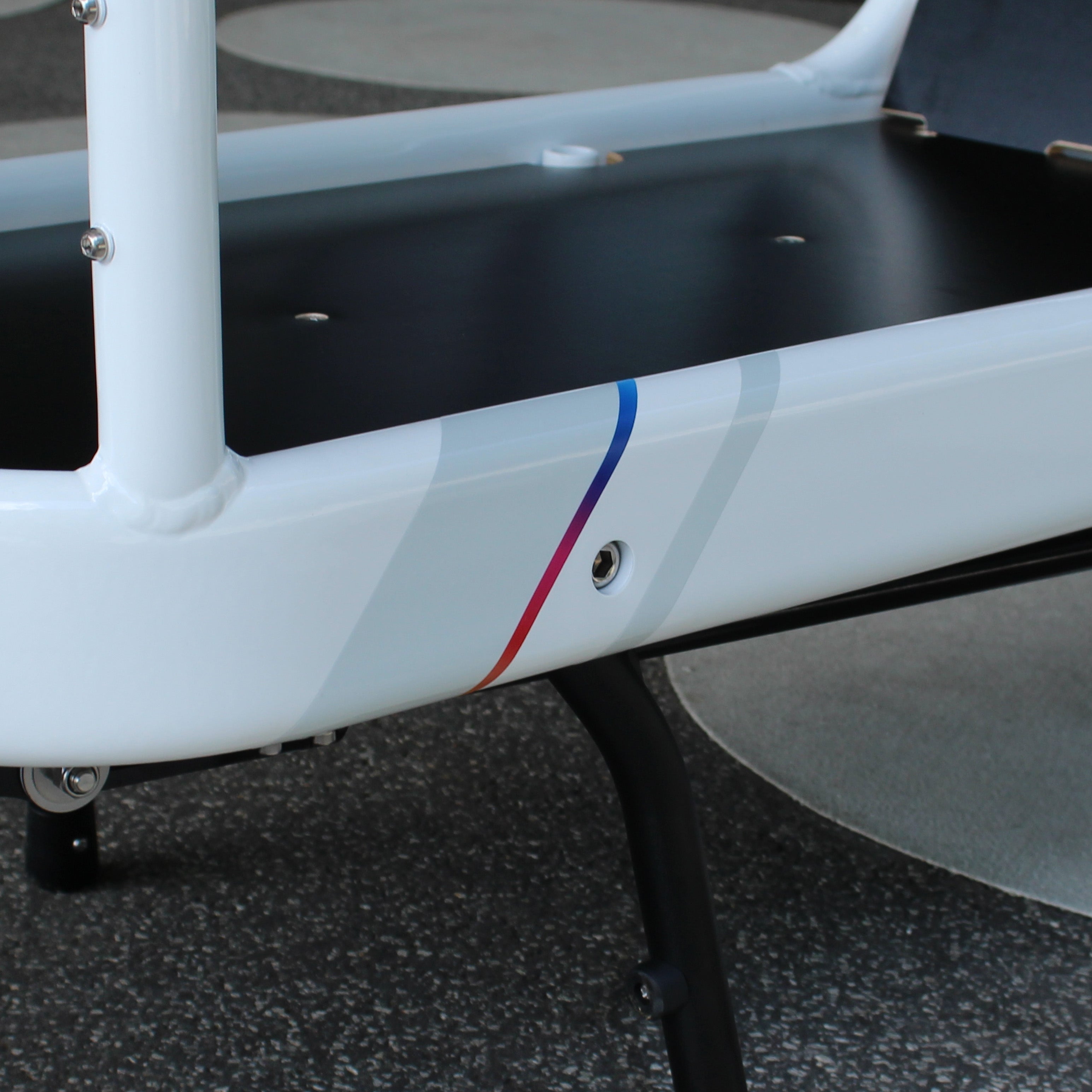 Detailansicht Bullitt Rahmen Ladefläche, weiß reflektierend mit regenbogen Farbstreifen