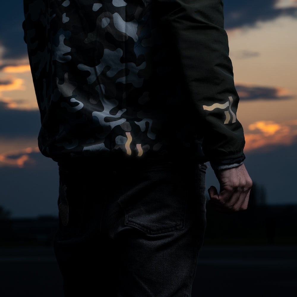 Camouflage Jacke mit goldenen Reflexaufklebern auf dem Feld