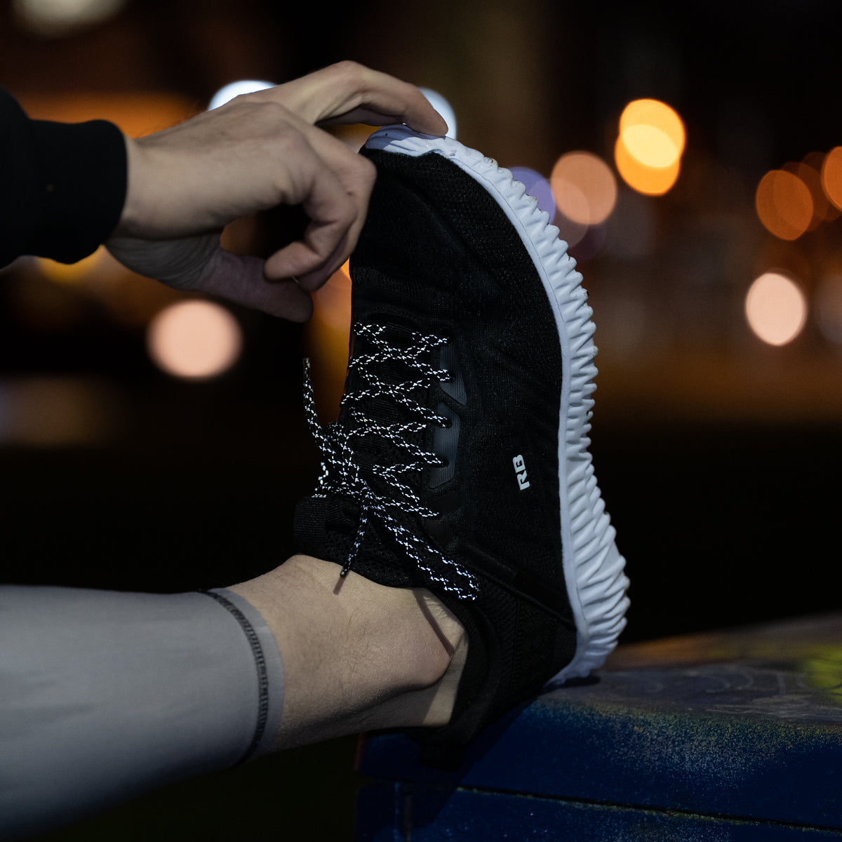 reflective laces on running shoes, with hand