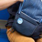 Woman sitting on blue bench searching her backpack