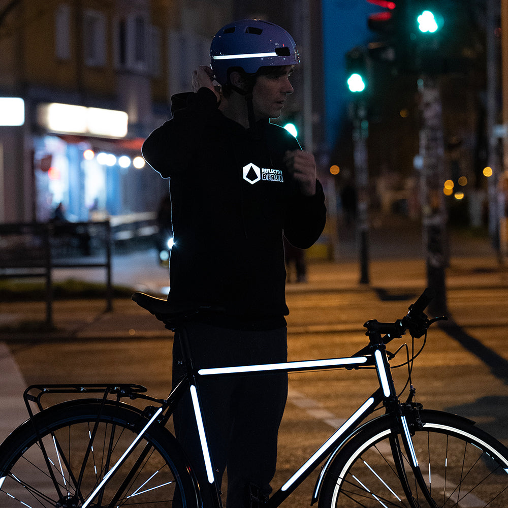 Man with reflective helmet and reflective bicycle with city background