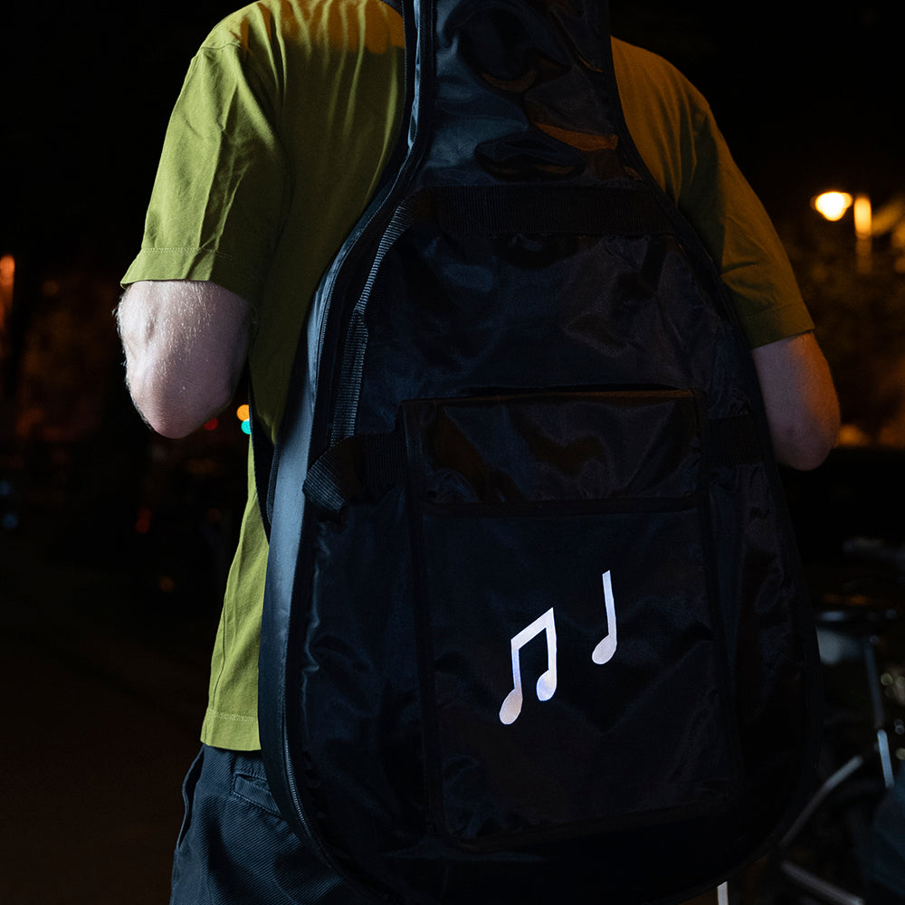 Reflective sticker on guitare gigbag with man in night street