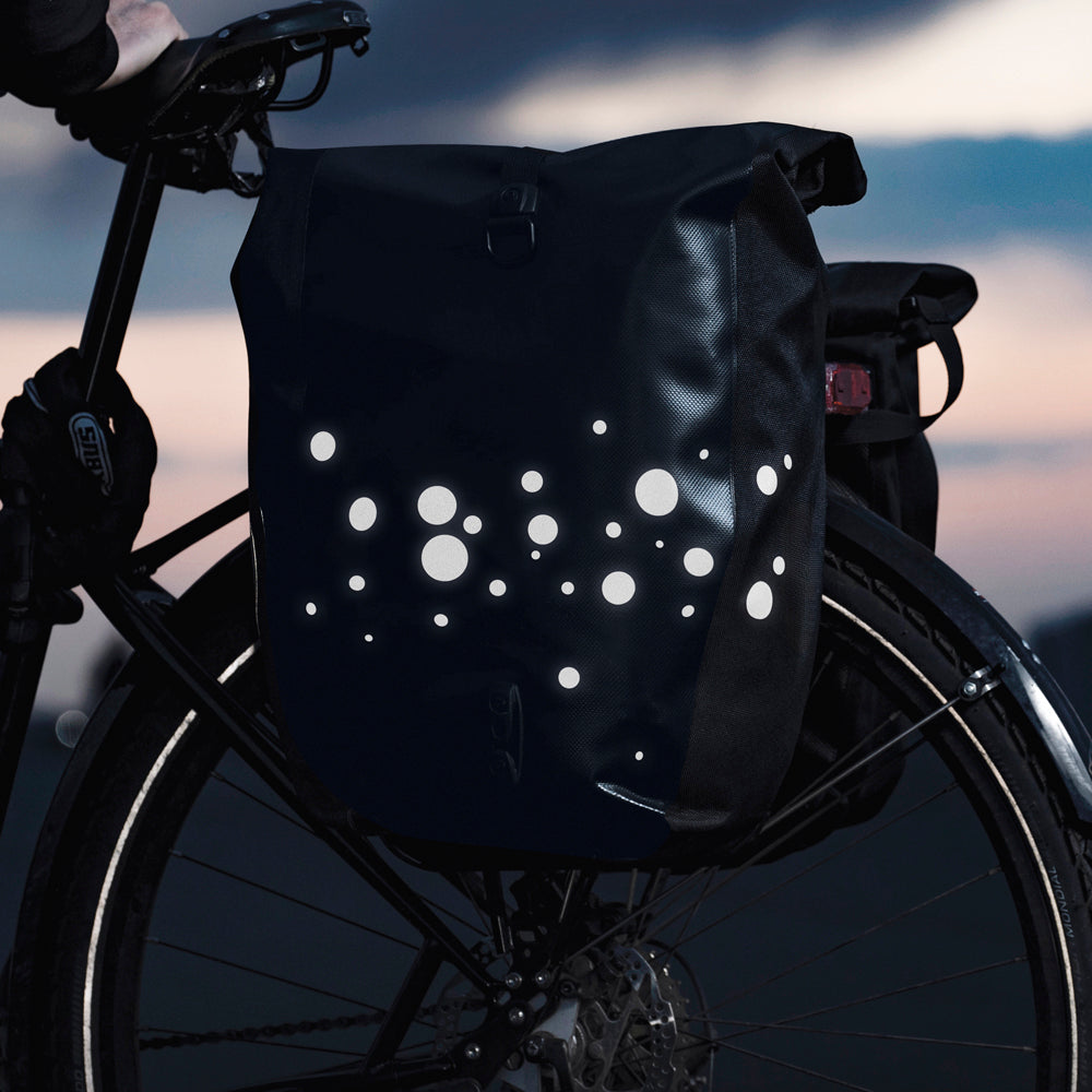 HIgh-viz reflective sticker on bicycle bag with sunset