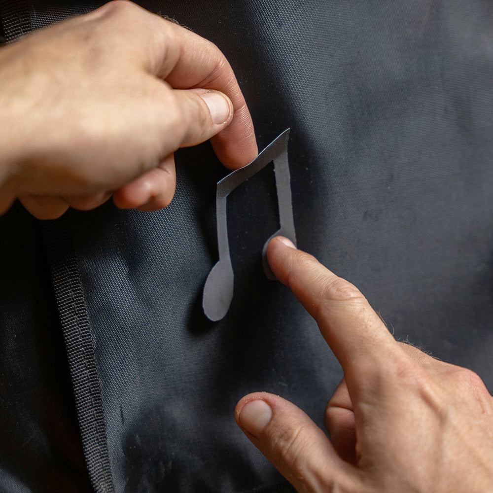 Applying reflective sticker on guitare gigbag