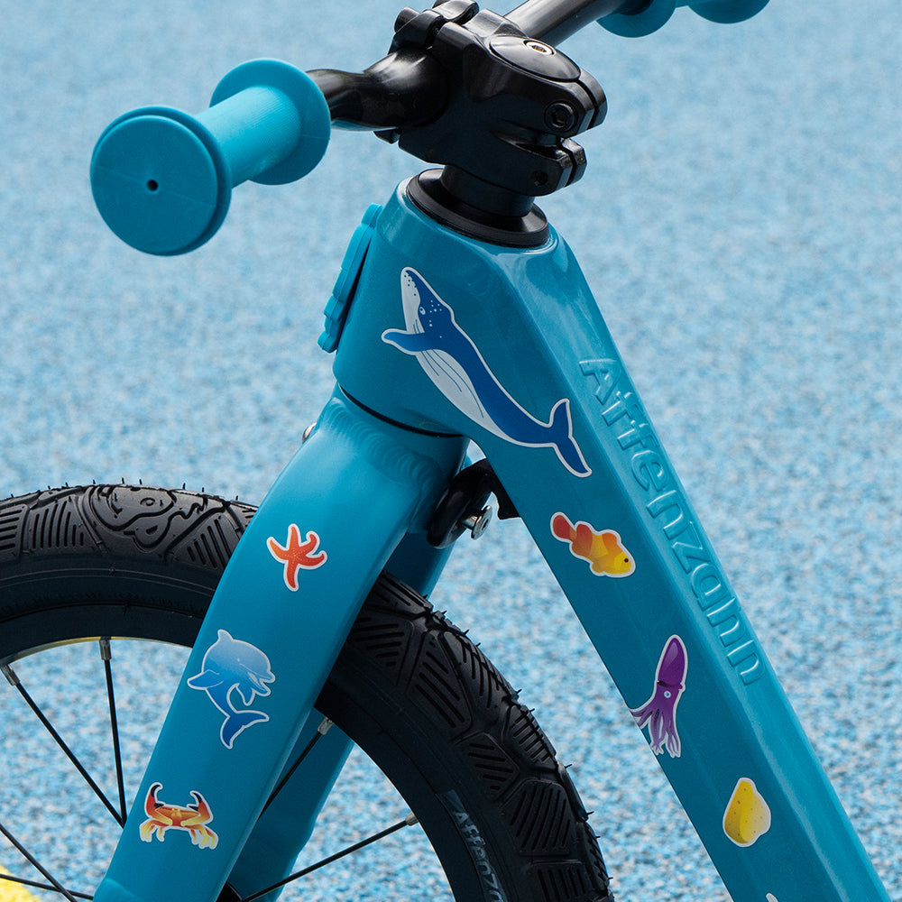 Close up of aqua design reflective set on blue kids bike and blurry background