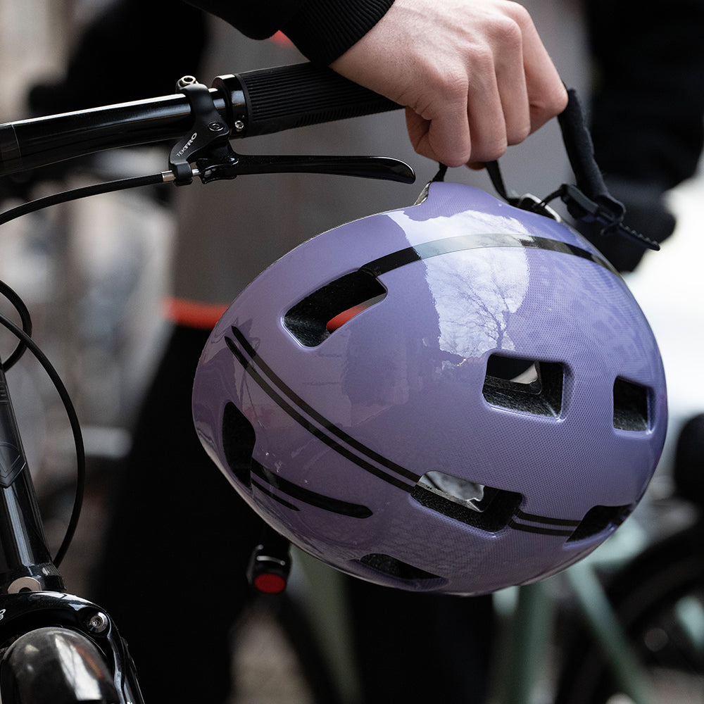 Helmet hanging from handlebar with black reflective stripes applied