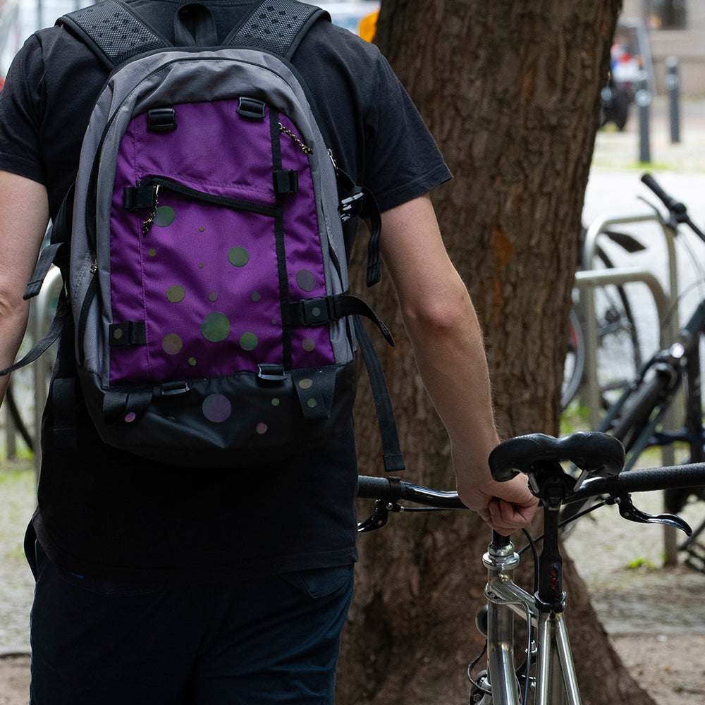 man wearing backpack walking with bicycle