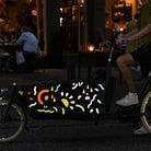 Reflective ticker totem applied on side box of cargo bicycle in night street