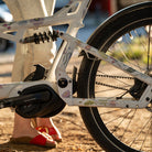 woman holding cargo bike with reflective flowers
