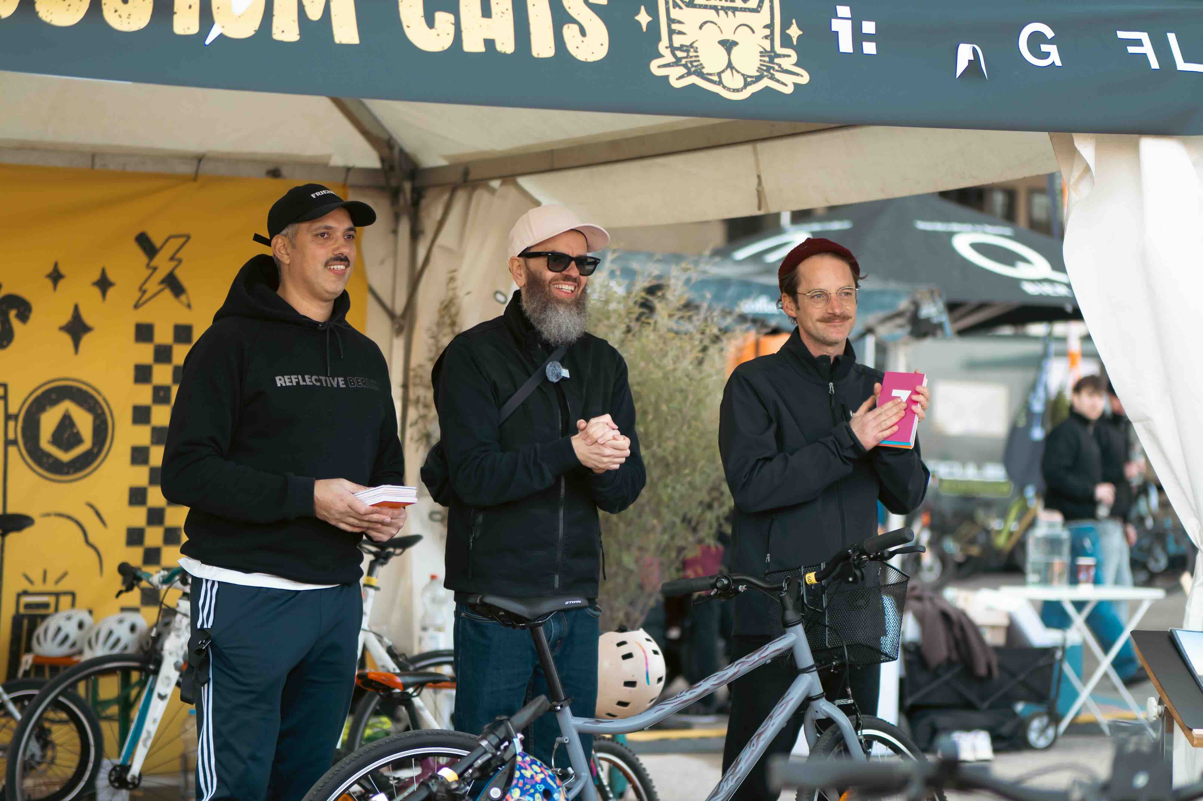 3 Männer bilden die Jury beim VELO Berlin Custom Cats Sticker Wettbewerb und freuen sich