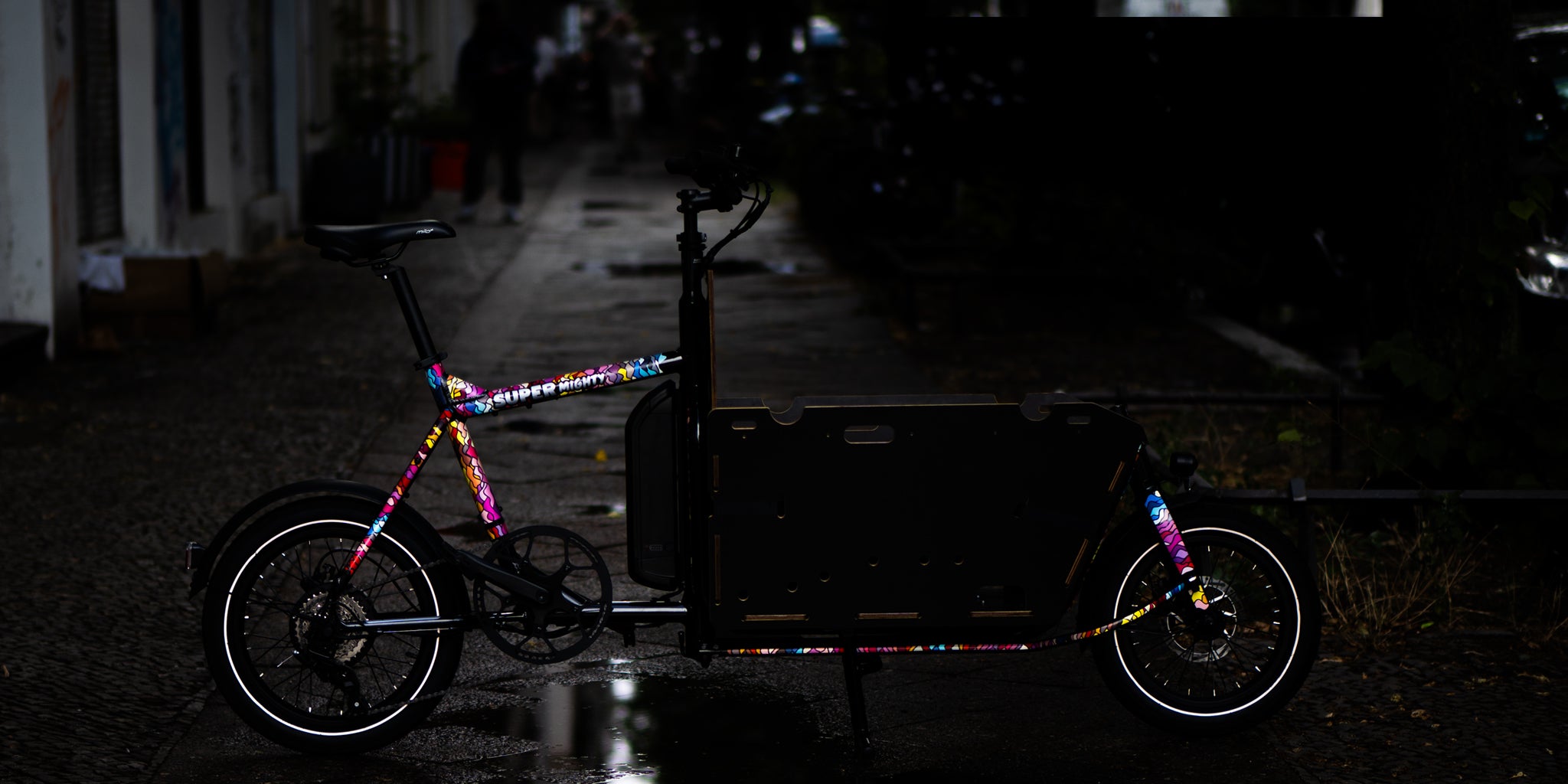 Cargo bicycle in street with reflective stickers and wet floor
