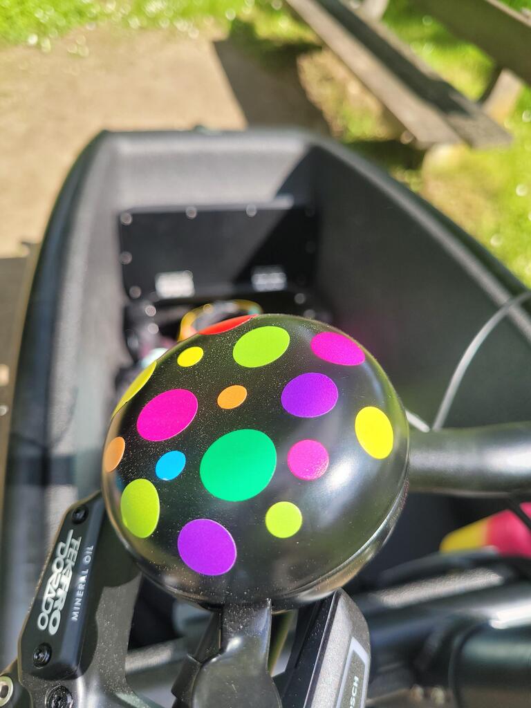 Bubbles Pop von REFLECTIVE Berlin auf Fahrradklingel mit stark reflektierenden bunten Kreisen für mehr Sichtbarkeit im urbanen Stil.