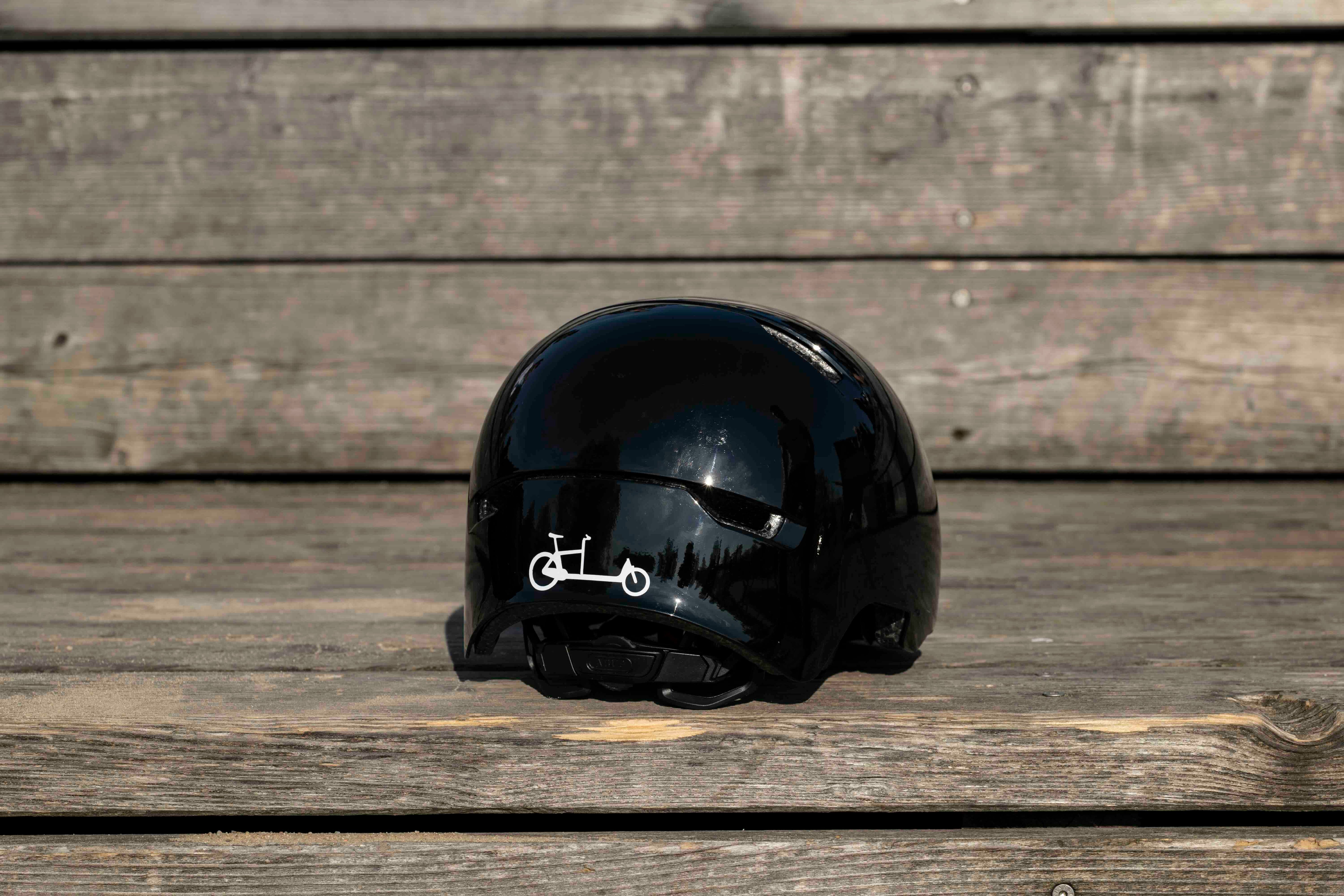 Cargobike Weiß von REFLECTIVE Berlin auf schwarzem Fahrradhelm mit stark reflektierendem Lastenradmotiv für mehr Sichtbarkeit im urbanen Stil.