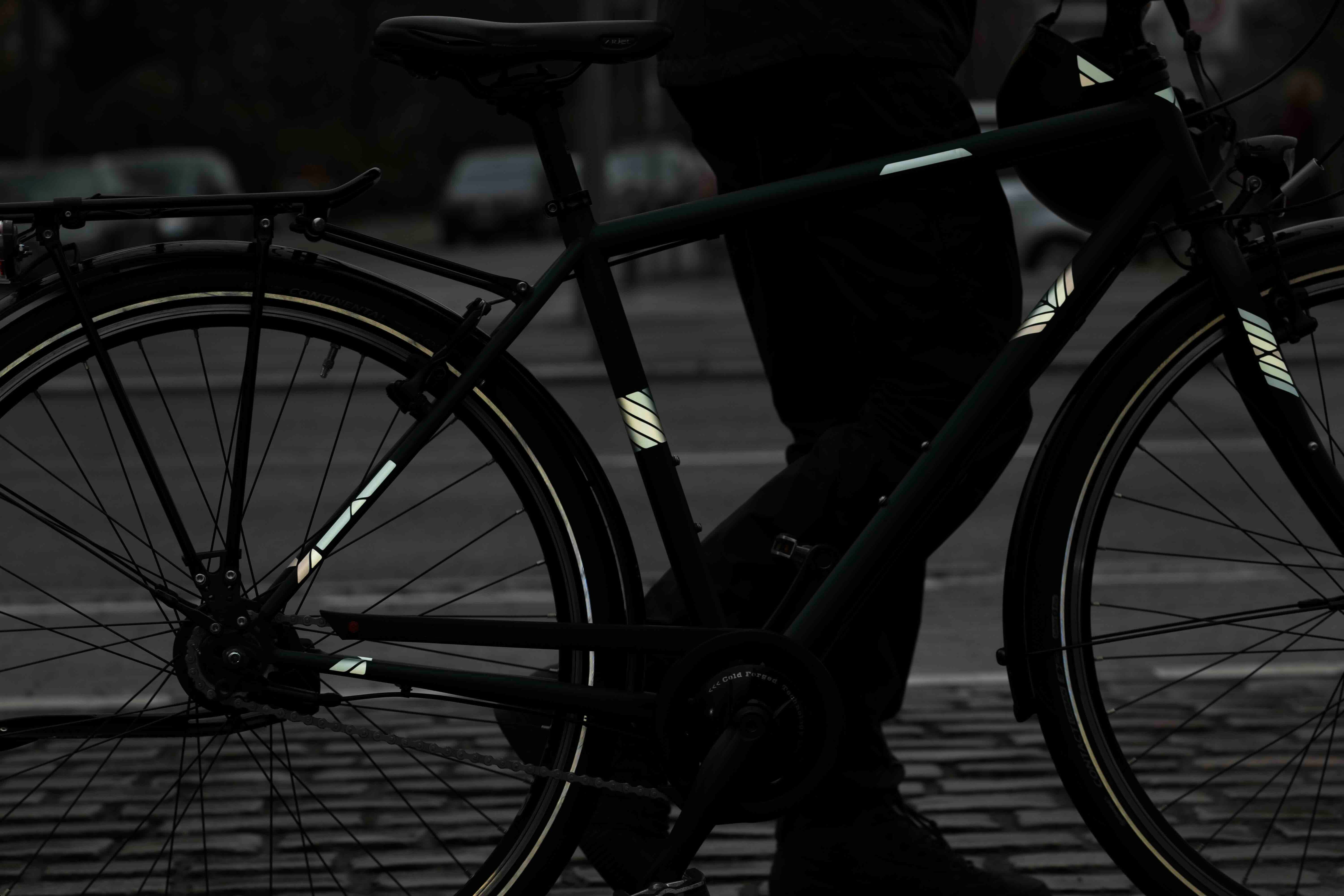 Delta Amber von REFLECTIVE Berlin auf Fahrradrahmen mit stark reflektierenden amberfarbenen Pfeilformen für mehr Sichtbarkeit im urbanen Stil.