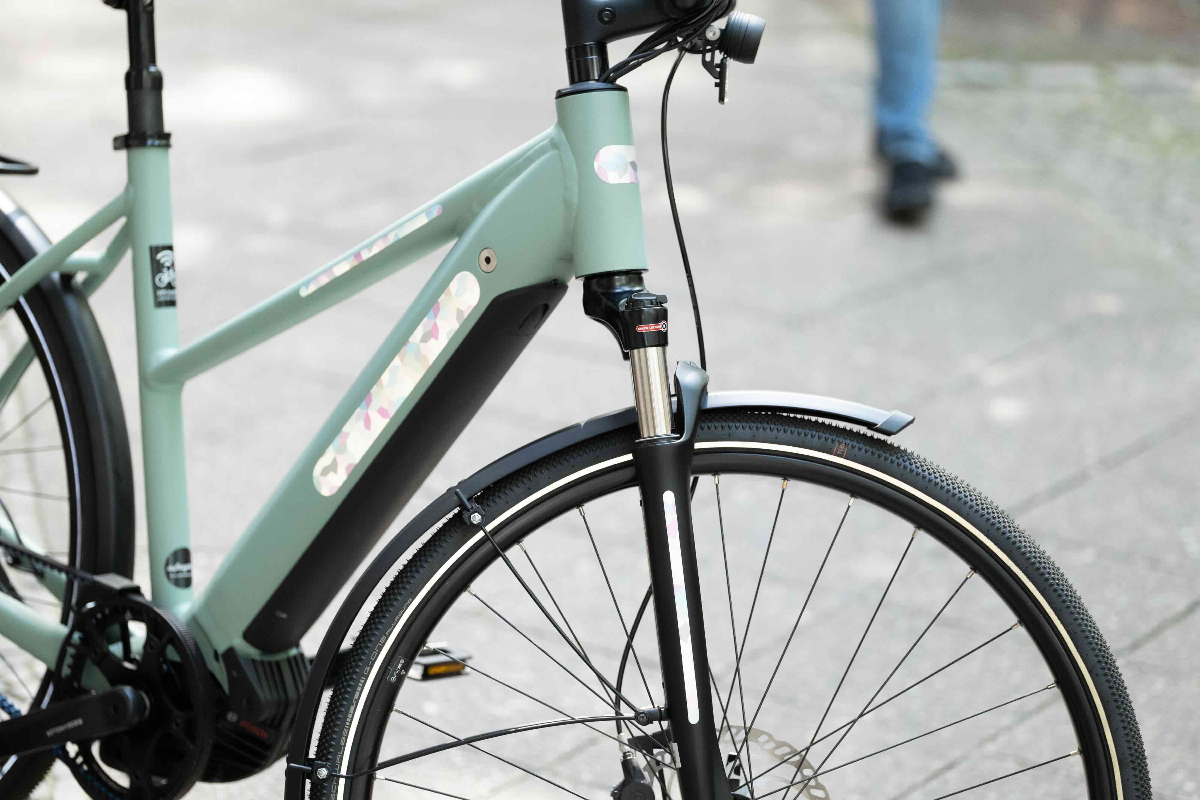 DIY Bloom Pastel von REFLECTIVE Berlin auf Fahrradrahmen mit stark reflektierenden floralen Formen für mehr Sichtbarkeit im urbanen Stil.
