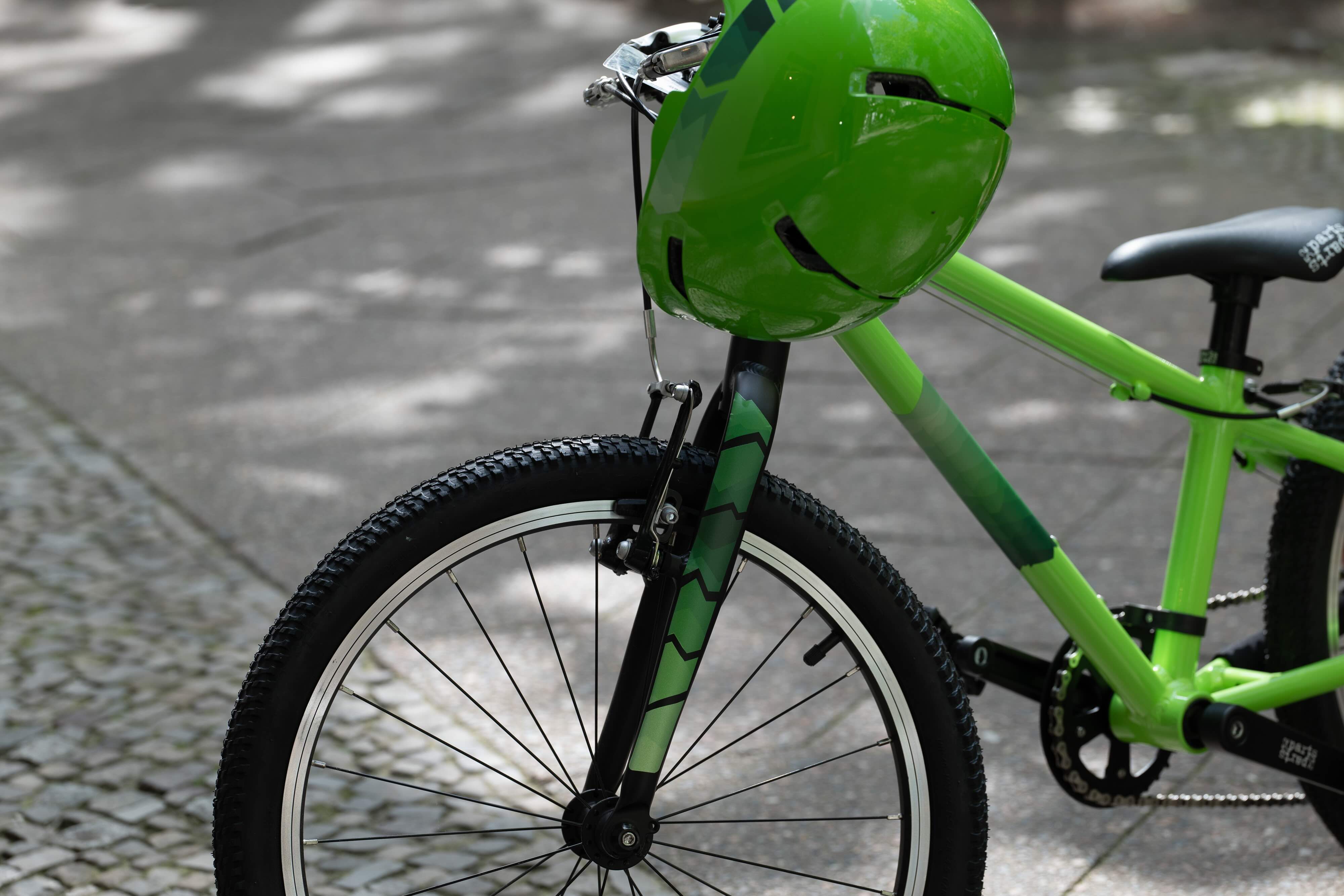 DIY Mountain Grün von REFLECTIVE Berlin auf Fahrrad und Helm, A4-Stickerbogen zum Selbstschneiden mit stark reflektierenden Bergformen für mehr Sichtbarkeit im urbanen Stil.