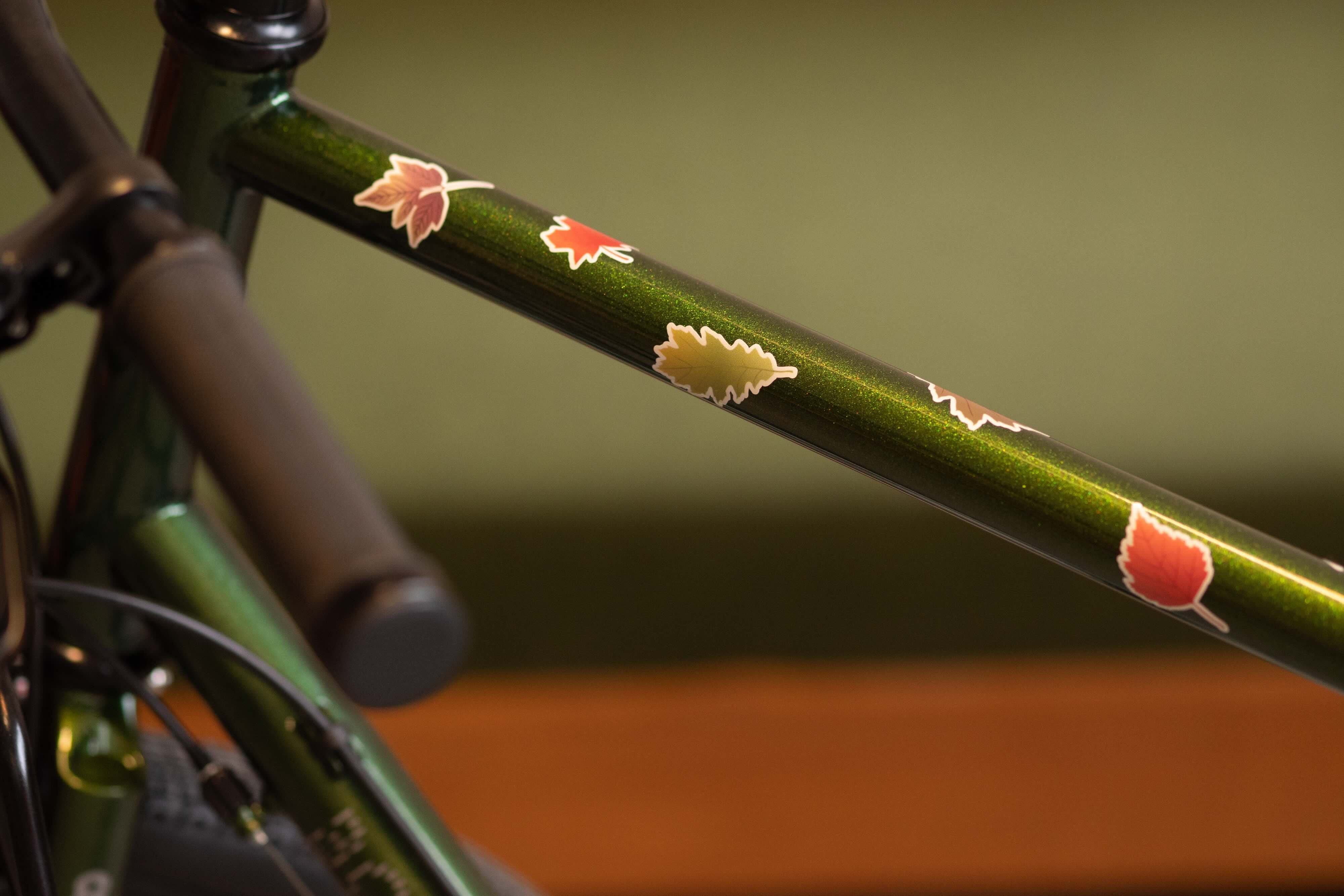 Leaves Sticker von REFLECTIVE Berlin auf grünem Fahrradrahmen mit stark reflektierenden Blattformen für mehr Sichtbarkeit im urbanen Stil.