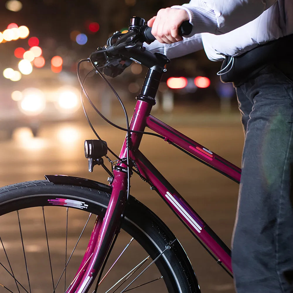 Reflektierender Aufkleber „Smudge“ in Farbvariante „pink“ auf Fahrradfelge. Reflektierender Aufkleber „Universal“ in Farbvarianten „pink“ auf Fahrradrahmen.  von REFLECTIVE Berlin.
