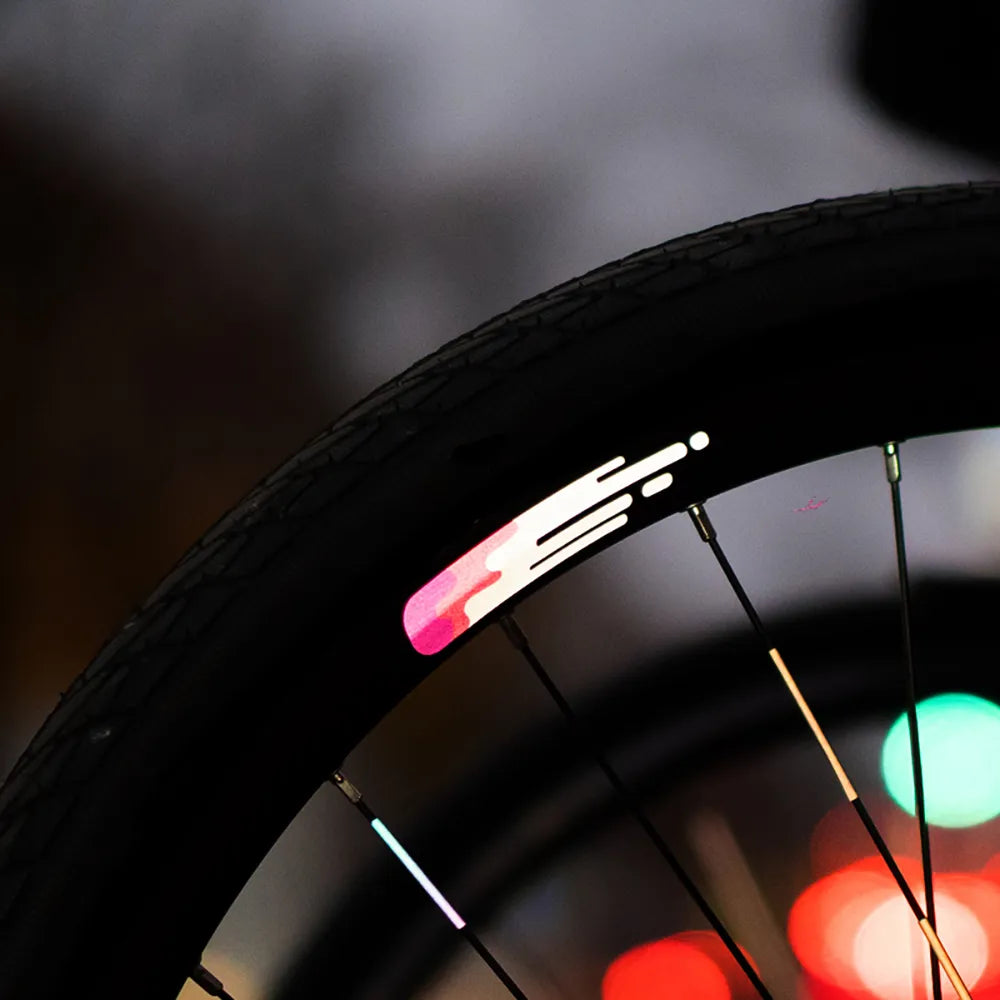 Reflektierender Aufkleber „Smudge“ in Farbvariante „pink“ auf Fahrradfelge in Detailaufnahme. von REFLECTIVE Berlin.
