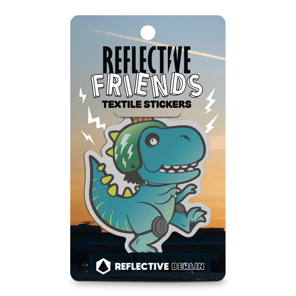 Reflektierender Aufkleber Textil Stoff „Lino“, ein T-Rex Dinosaurier mit Fahrradhelm und Knieschonern aus der Produktserie „Reflective Friends“ in Produktverpackung von REFLECTIVE Berlin.
