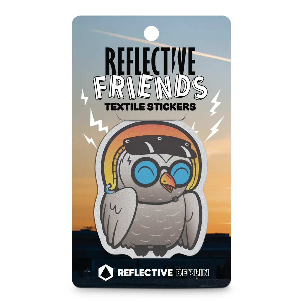 Reflektierender Aufkleber Stoff Textil „Olli“ eine Eule mit gelbem Fahrradhelm aus der Produktserie „Reflective Friends“ in Produktverpackung REFLECTIVE Berlin.
