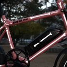 Seitliche Detailaufnahme vom Super Bicycles Mini in lachs Farbe mit Reflexstickern in der Form von Knochen.