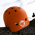 Reflektierender Aufkleber „Affe“ in Farbvariante „weiß“ auf einem orangen Fahrradhelm vor weißem Hintergrund von REFLECTIVE Berlin.